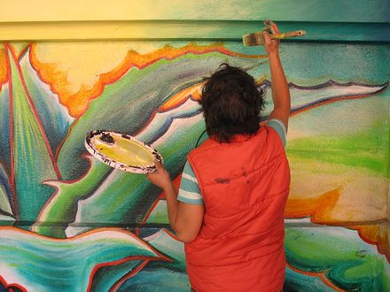 Painter restoring MaestraPeace, mural on the San Francisco Women's Building.