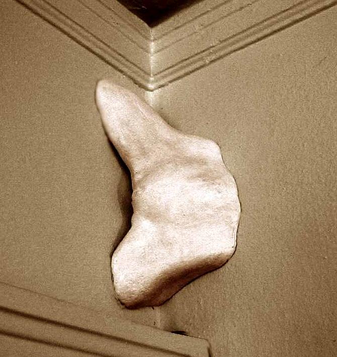 a plaster torso emerges from a room-corner, by Wayan