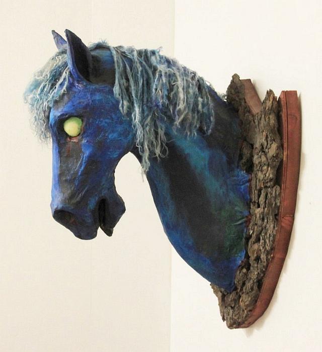 Horse head hung on bark; papier-mache dream sculpture by Mardi Storm.