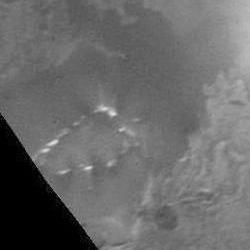 Plumes at the feet of an Uluru-type rock rising 4 km from the plains of Io