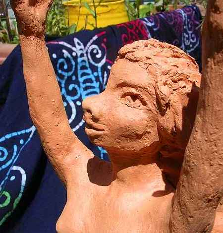 Face of a lebbird woman looking up ecstatically. Feline features but high forehead and large eyes (nocturnal). Unfired clay sculpture. Click to enlarge.