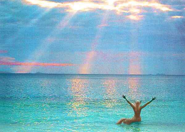 A beach, clouds, sunrays in a halo. Standing in shallow turquoise water, is a cheetaur, a feline centauroid, arms raised joyfully.
