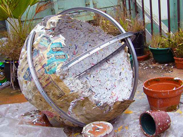 A papier-mache model of a huge ocean-world called Lyr, burst open, showing girders.