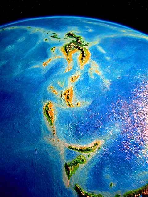 High orbital photo of the Fiery Islands on Lyr, a model of a huge sea-world. Looking south: in foreground, Cape Mistwood on Corona, then Fluoch, Rennhi, the Ferranians, and near the equator, the largest, Lokon. Click to enlarge.