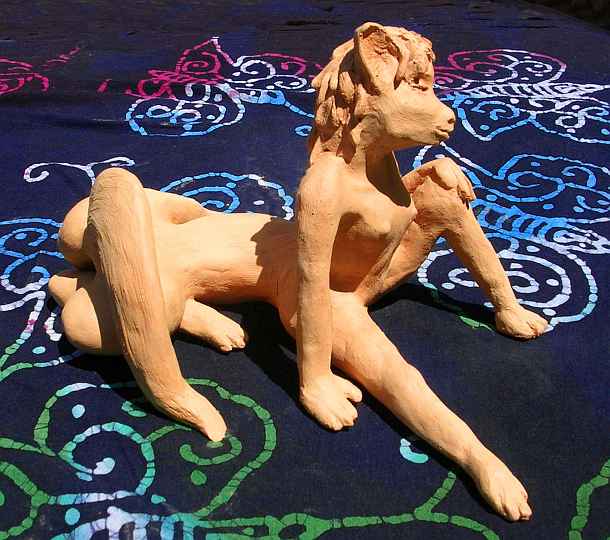 Vixentaur; a vulpine female centauroid reclining, half-curled, seen from left side; unfired clay sculpture.  Click to enlarge.