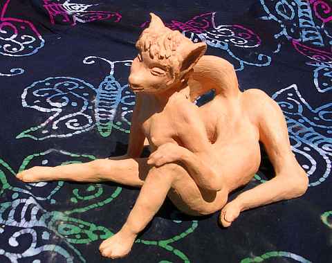 Vixentaur; a vulpine female centauroid reclining, half-curled, seen from right side; unfired clay sculpture by Wayan. Click to enlarge.